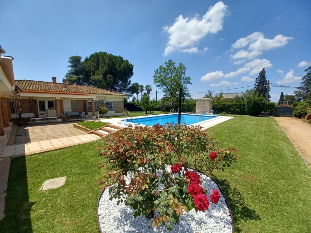 a garden with a swimming pool and flowers in a yard at Remanso de Paz cerca de Sevilla DreamerTu in Palomares del Río
