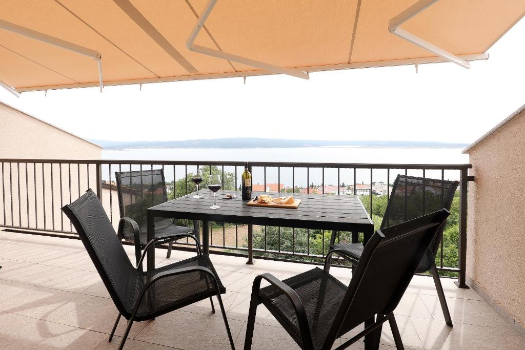 a black table and chairs on a balcony at Apartments Via Sole Dramalj in Dramalj
