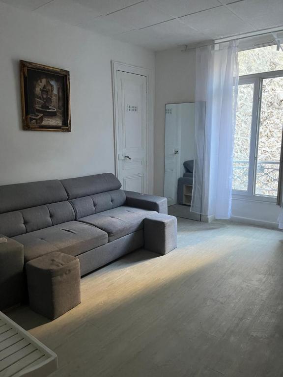 un salon avec un canapé et une fenêtre dans l'établissement T2 fonctionnel à 100m Vieux port, à Marseille