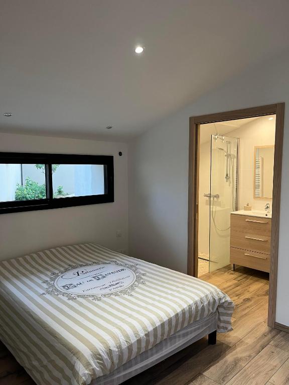 une chambre avec un grand lit et une salle de bain dans l'établissement Chambre indépendante avec jardin - 100m de la mer, à Langrune-sur-Mer