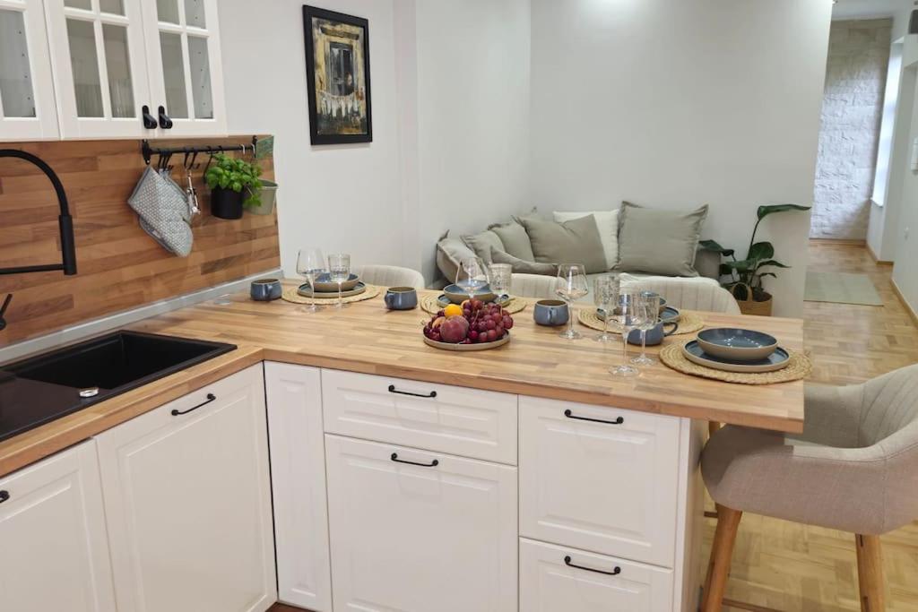 a kitchen with a table with a bowl of fruit on it at Mala Lu Central Apartment in Varaždin