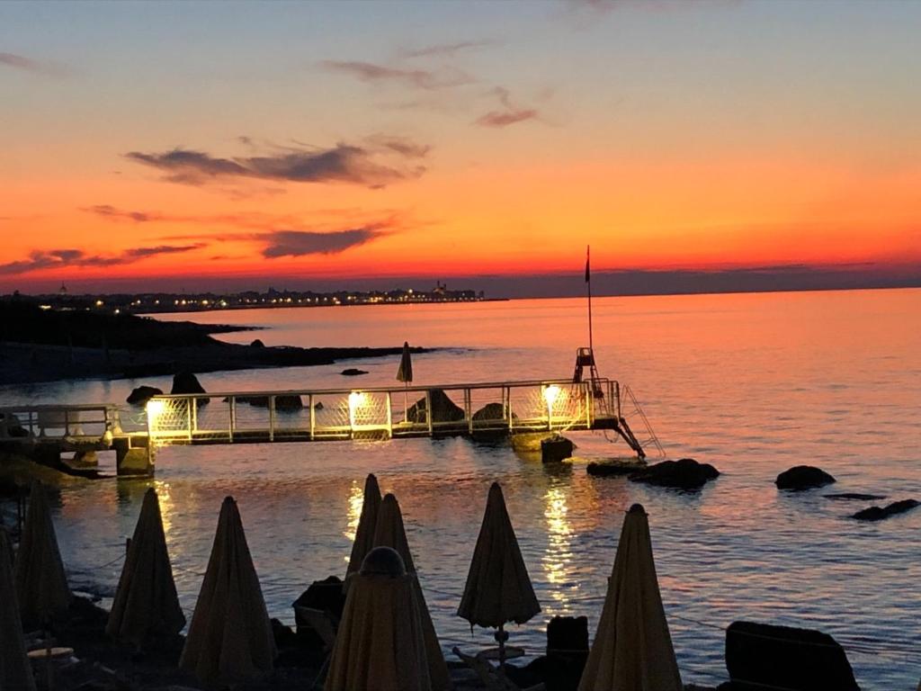 a dock with lights in the water at sunset at Riva Sweet Home in Giovinazzo