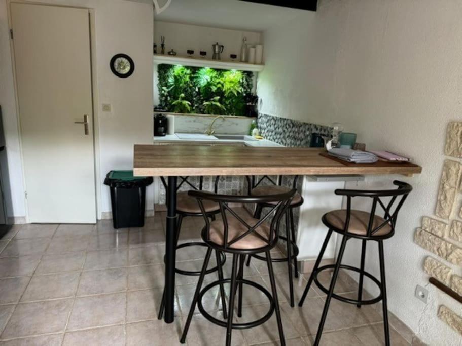 une cuisine avec un comptoir et des tabourets dans une pièce dans l'établissement Maisonnette en Ardèche, à Saint-Martin-dʼArdèche