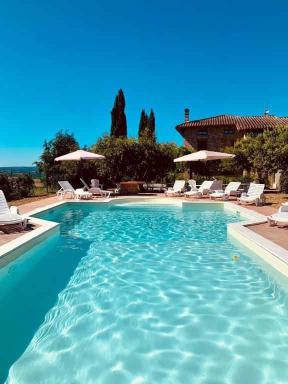 a large swimming pool with chairs and umbrellas at Villa Tre Laghi Vista Paradiso Piscina acqua salata provincia Perugia conf Toscana 22 posti in Castiglione del Lago