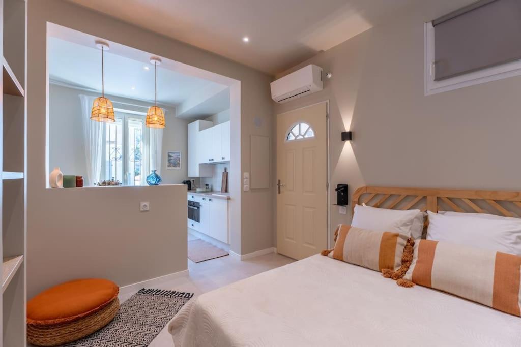 Cet appartement comprend une chambre avec un lit blanc et une cuisine. dans l'établissement Studio - Calme - à 700m de la plage et calanques, à Marseille