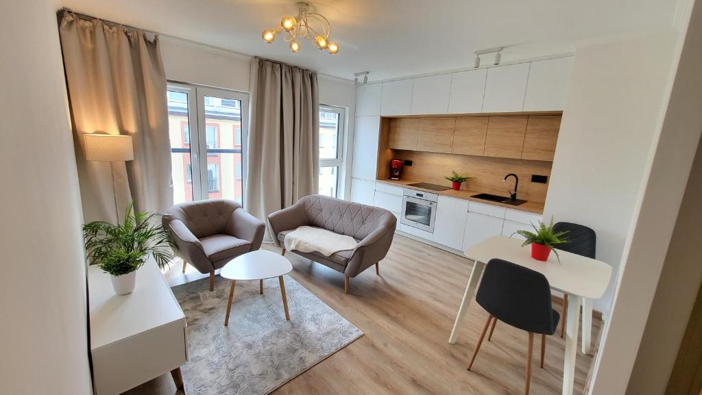 a living room with two chairs and a kitchen at Serce Szczecina in Szczecin