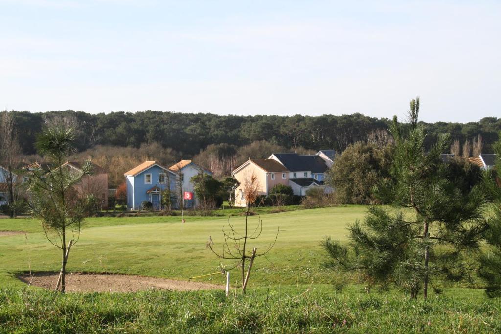 - une vue sur un parcours de golf avec des maisons et des arbres dans l'établissement Maison calme sur golf, mer & campagne - Port Bourgenay, à Talmont-Saint-Hilaire