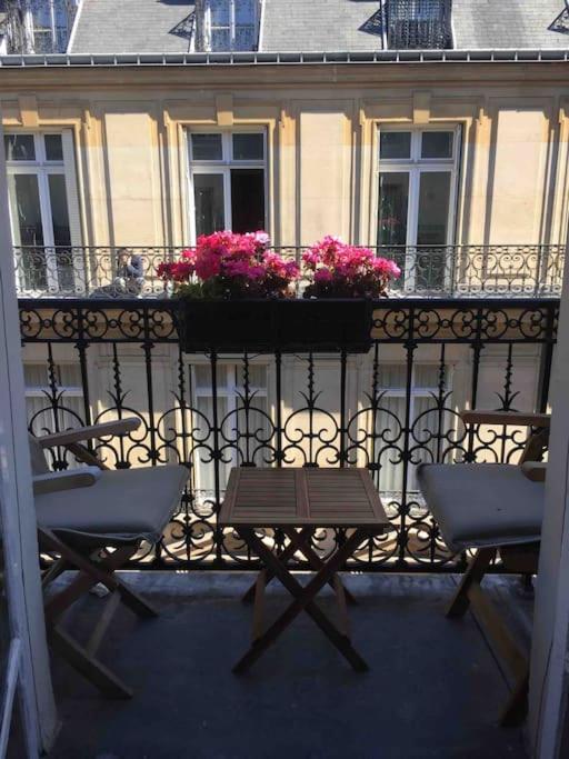 d'une table et de chaises sur un balcon fleuri dans l'établissement Côté Arc de Triomphe, à Paris