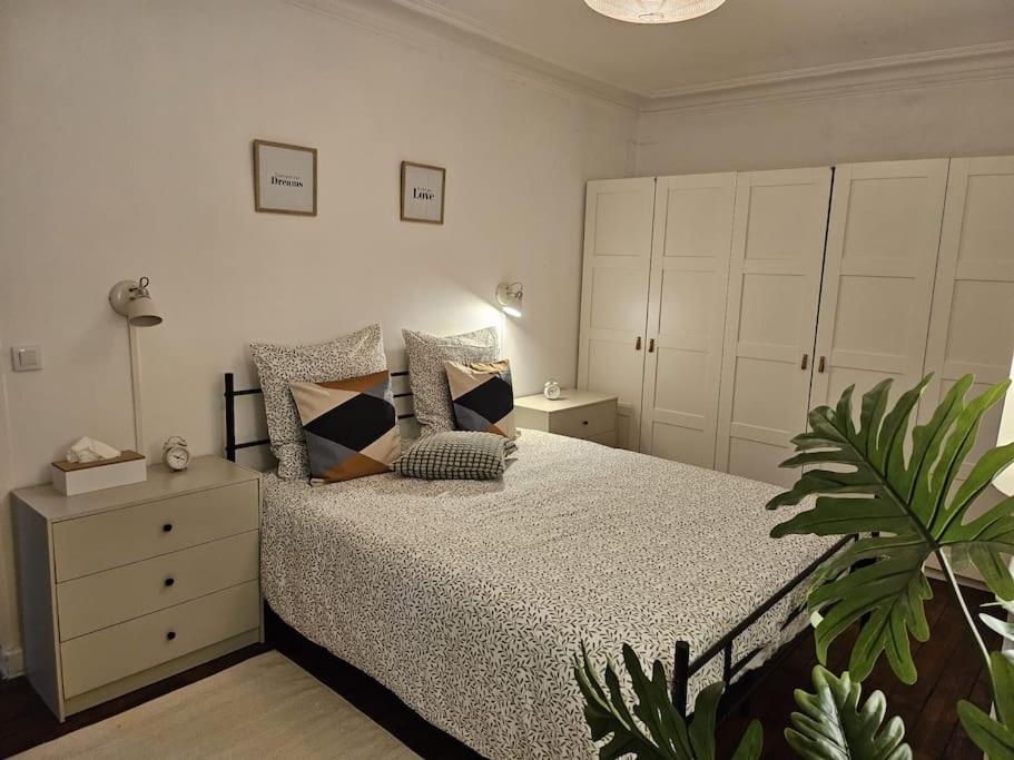 - une chambre avec un lit doté d'oreillers et d'une plante dans l'établissement Charmant Nice appartement 5 personnes people max, à Paris