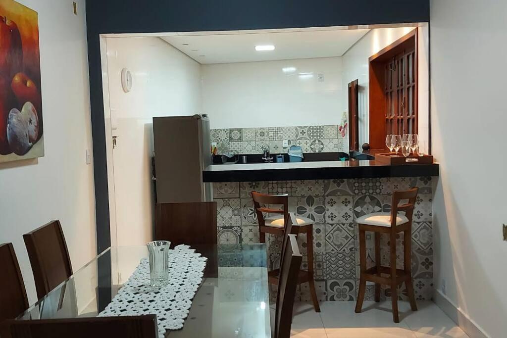 eine Küche mit einem Glastisch und einigen Stühlen in der Unterkunft Casa do Cristiano no bairro Rosário in Ouro Preto