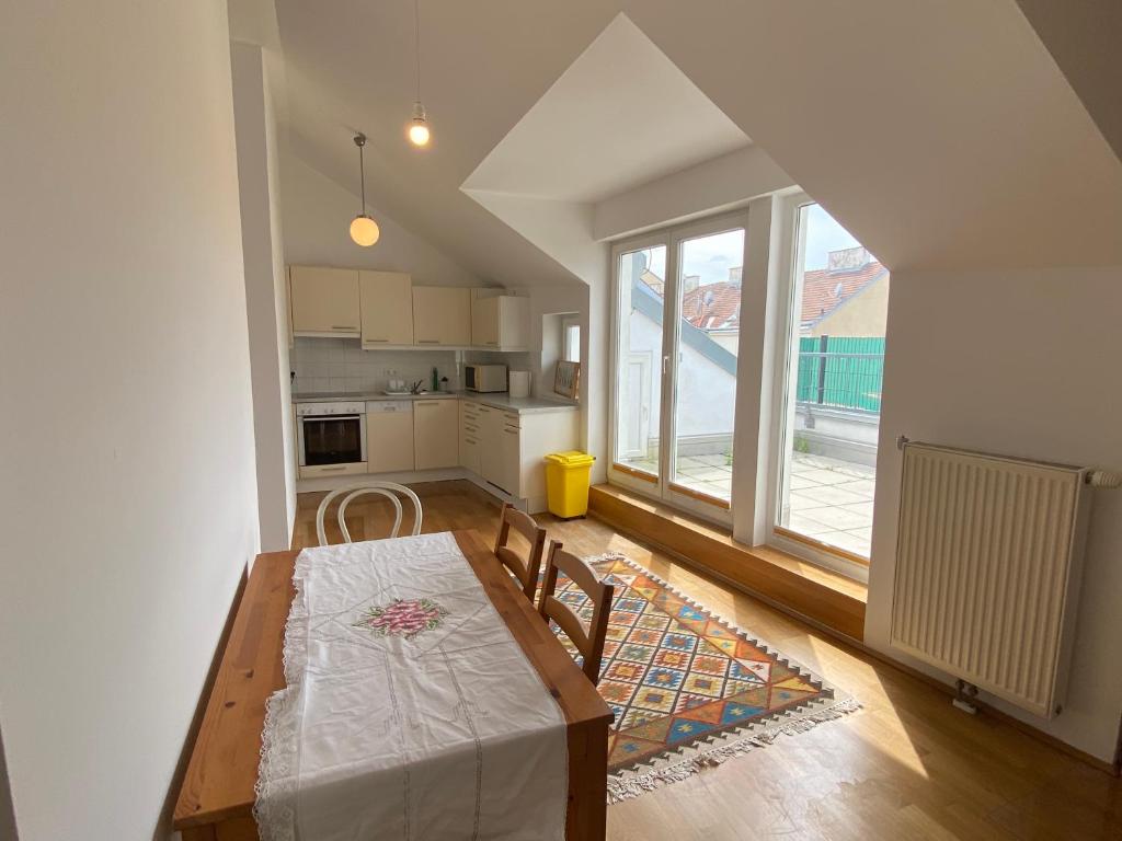 a kitchen with a wooden table and a large window at Luxury Penthouse near Metro, Train Station and 15 mins Center in Vienna