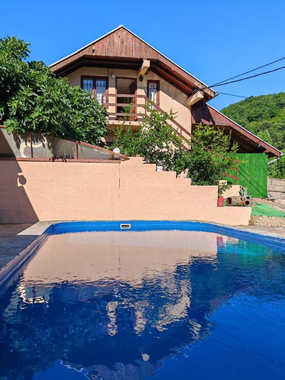 a house with a swimming pool in front of a house at Apartman Popović in Niš