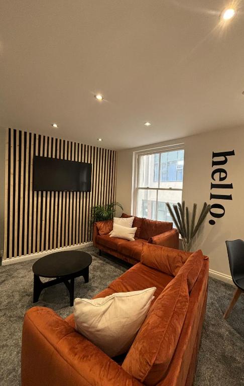 a living room with two couches and a television at Modern two bed apartment in Hull