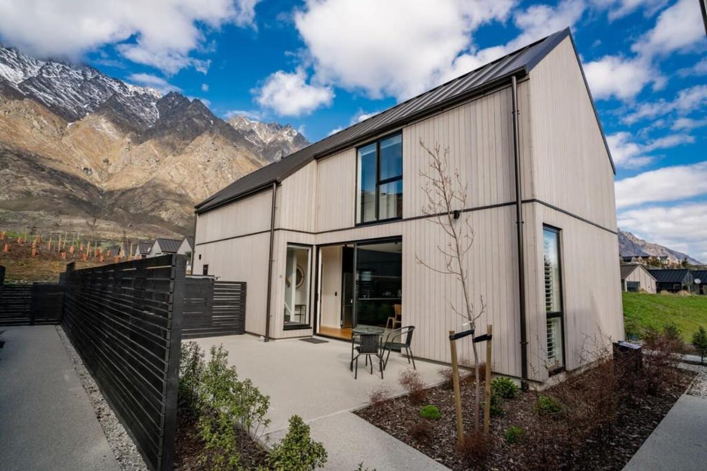 a modern house with mountains in the background at Nestled below the Remarkables in Queenstown
