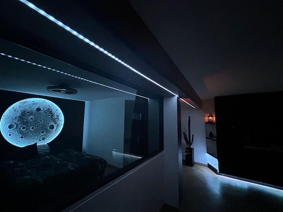 une pièce sombre avec une pièce avec un lit et une lumière dans l'établissement Appartement vue Saône et Lune, à Mâcon