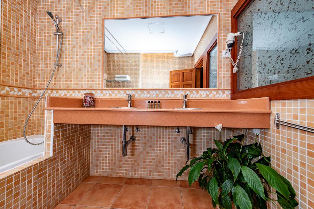 a bathroom with a sink and a mirror at Calas Beach Corralejo in Corralejo