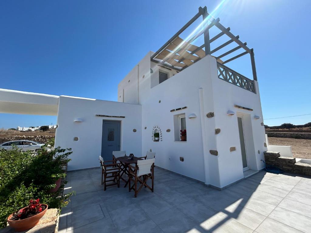 a white house with a table and chairs on a patio at Antiparos Diamond in Antiparos Town