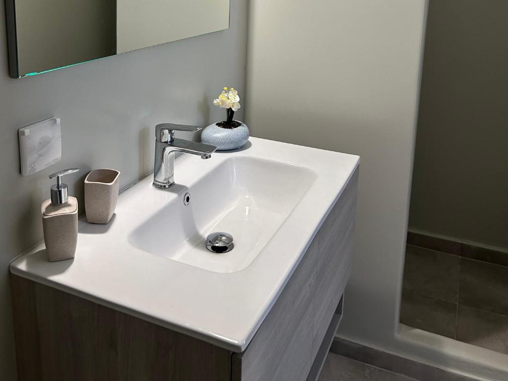 a bathroom with a white sink and a mirror at Antiparos Diamond in Antiparos Town