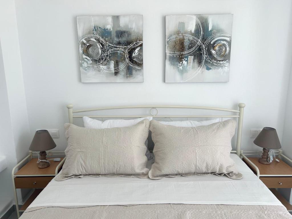 a bedroom with a bed with three pictures on the wall at Antiparos Diamond in Antiparos Town