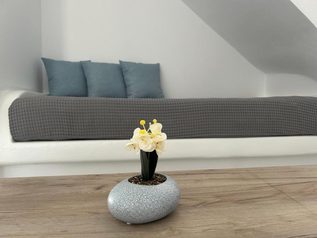 a vase with flowers on a table in a living room at Antiparos Diamond in Antiparos Town