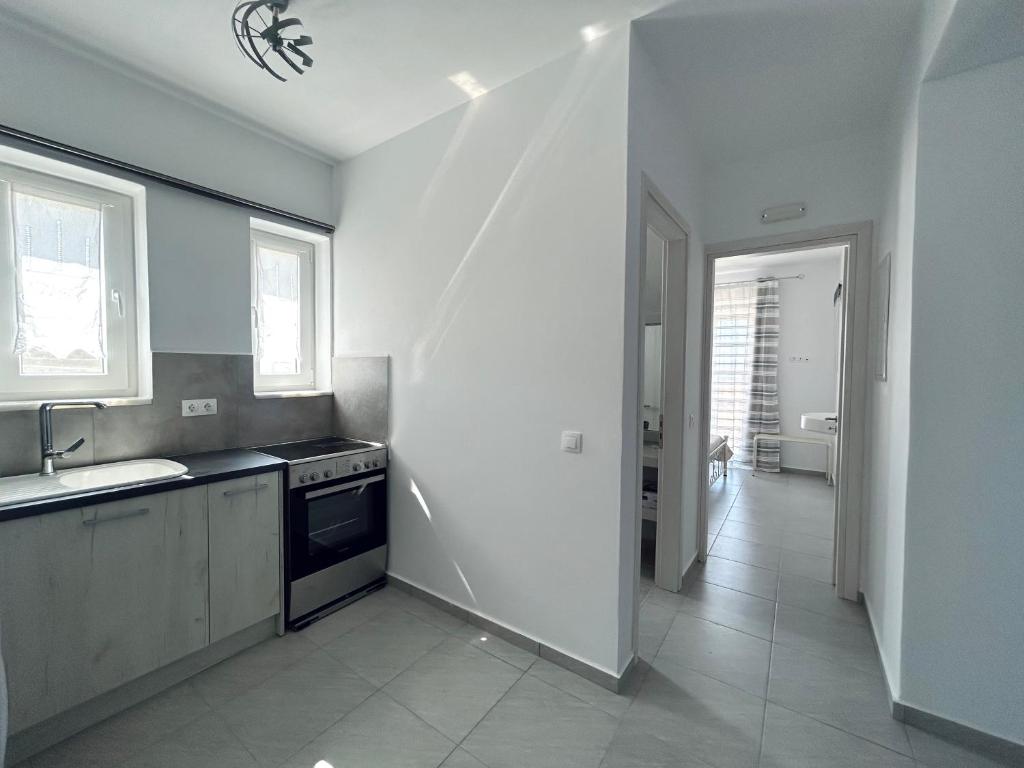 a white kitchen with a sink and a stove at Antiparos Diamond in Antiparos Town