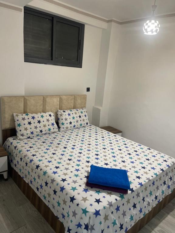 een slaapkamer met een bed met een blauw kussen erop bij Appart malabata in Tanger