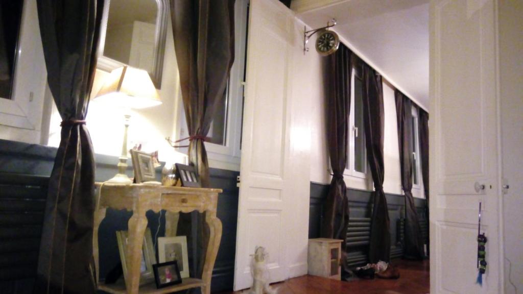 un couloir avec des rideaux et une table avec une lampe dans l'établissement Jeux olympiques Paris 2024, à Rouen