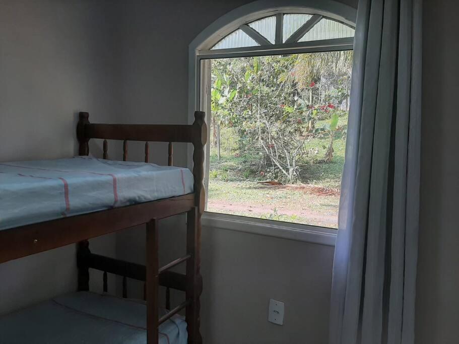 a bedroom with a bunk bed and a window at Sonho do Mar - Ilha do Teixeira in Antonina