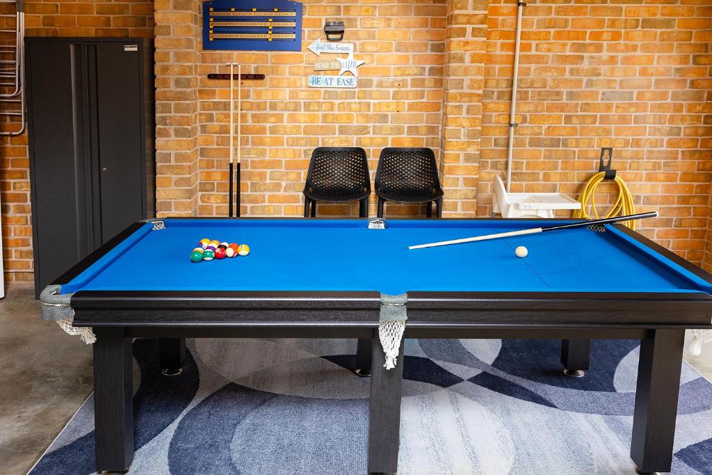 a pool table in a room with two chairs at Magpie Rest in Forster