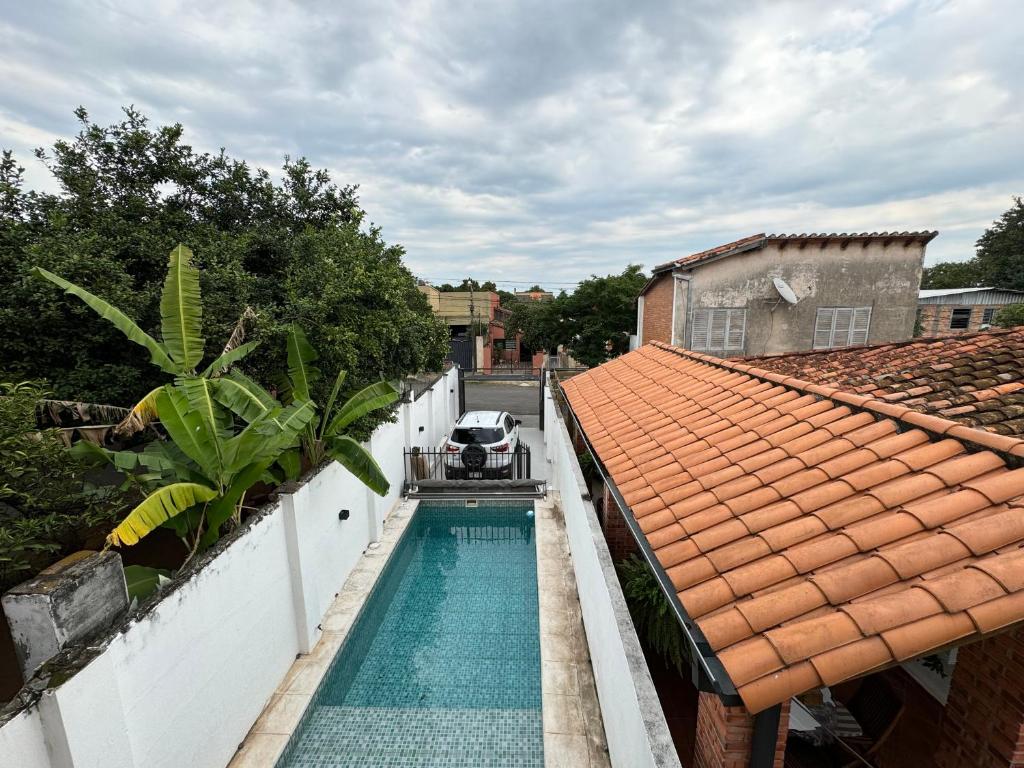 a swimming pool next to a house with a roof at Casa SIL in Asunción