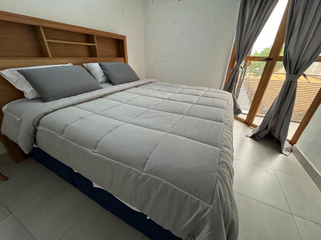 un letto grande in una camera da letto con una grande finestra di Casa Privada con Piscina y Parking Gratis en Asunción ad Asunción