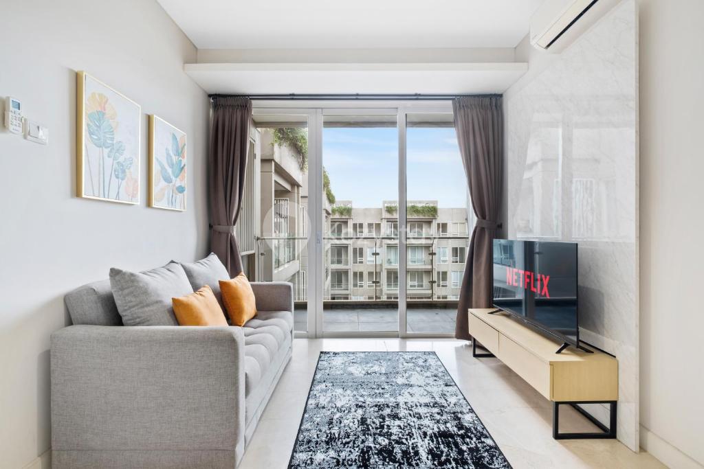 a living room with a couch and a tv at Dahayu by Kozystay - Paskal in Bandung
