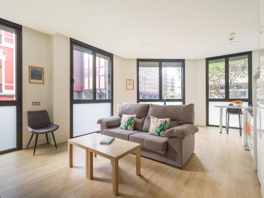 ein Wohnzimmer mit Sofa und Tisch in der Unterkunft VIVENTE - Viviendas Vacacionales in Guanarteme