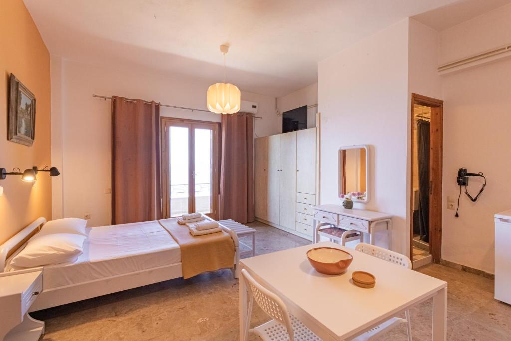 a bedroom with a bed and a table at Dimitra's Studios in Stoupa