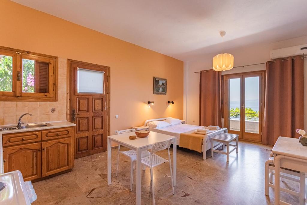 a room with a bed and a kitchen with a table at Dimitra's Studios in Stoupa