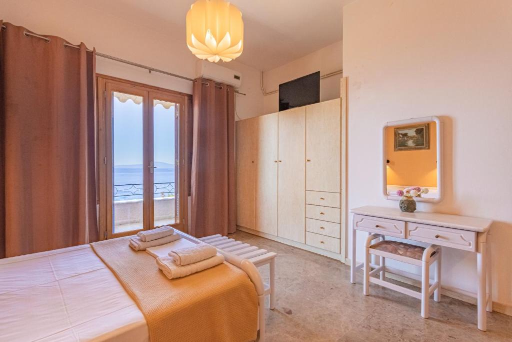 a bedroom with a bed and a desk and a window at Dimitra's Studios in Stoupa