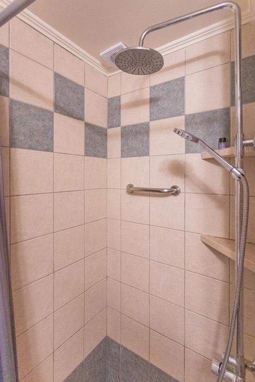a bathroom with a shower with a glass door at Dimitra's Studios in Stoupa