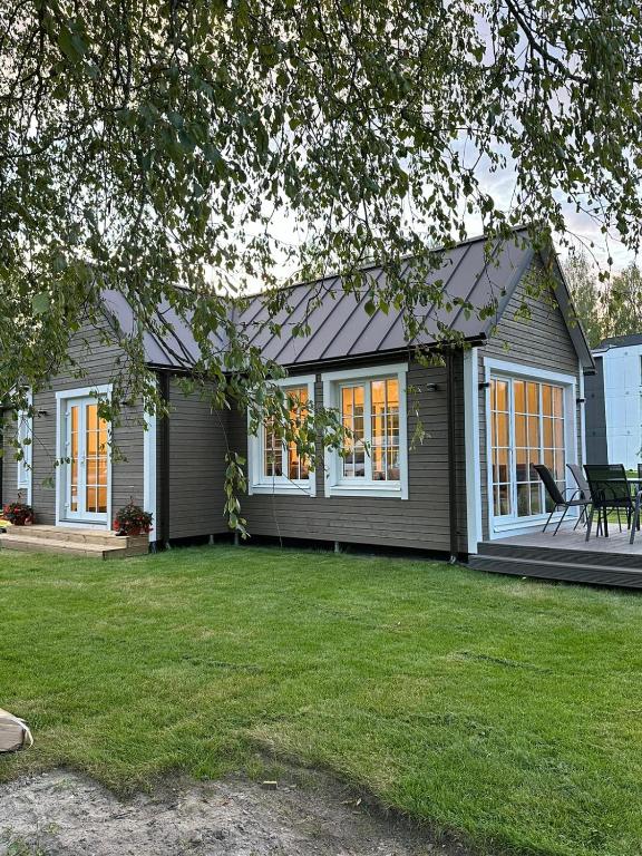 a house with a lawn in front of it at Melluži tiny house 60m2 in Jūrmala