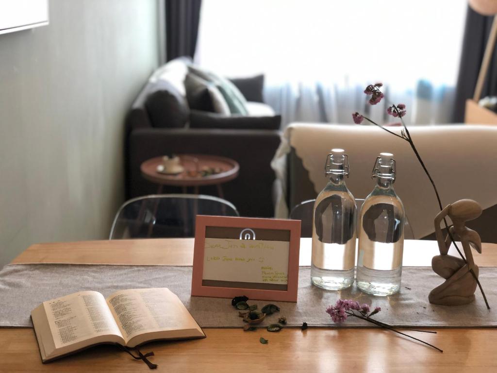 un tavolo con due bottiglie di vino e un libro di Sky Suites KLCC by Psalm Space exclusively for female travellers a Kuala Lumpur