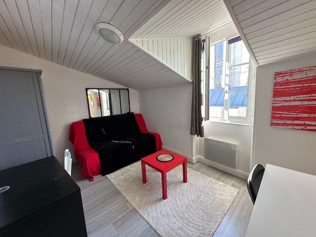 - un salon avec un canapé rouge et une table rouge dans l'établissement Charmant studio Carmes 5 - CDDT, à La Rochelle