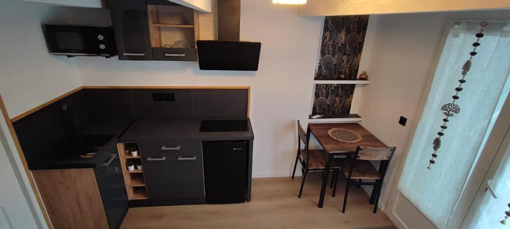 Il comprend une petite cuisine et une salle à manger avec une table. dans l'établissement Studio avec jardin, à Six-Fours-les-Plages