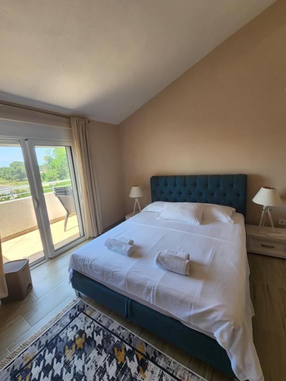 a bedroom with a large bed and a large window at Sunrise house apartments in Ulcinj