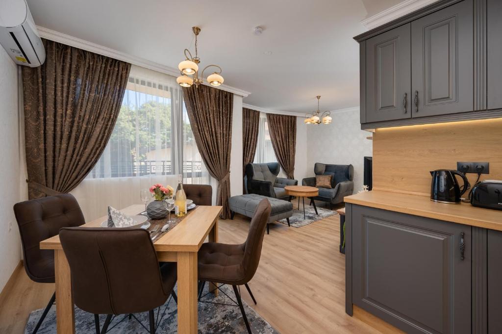 een keuken en woonkamer met een tafel en stoelen bij Prestige Central Apartments in Varna