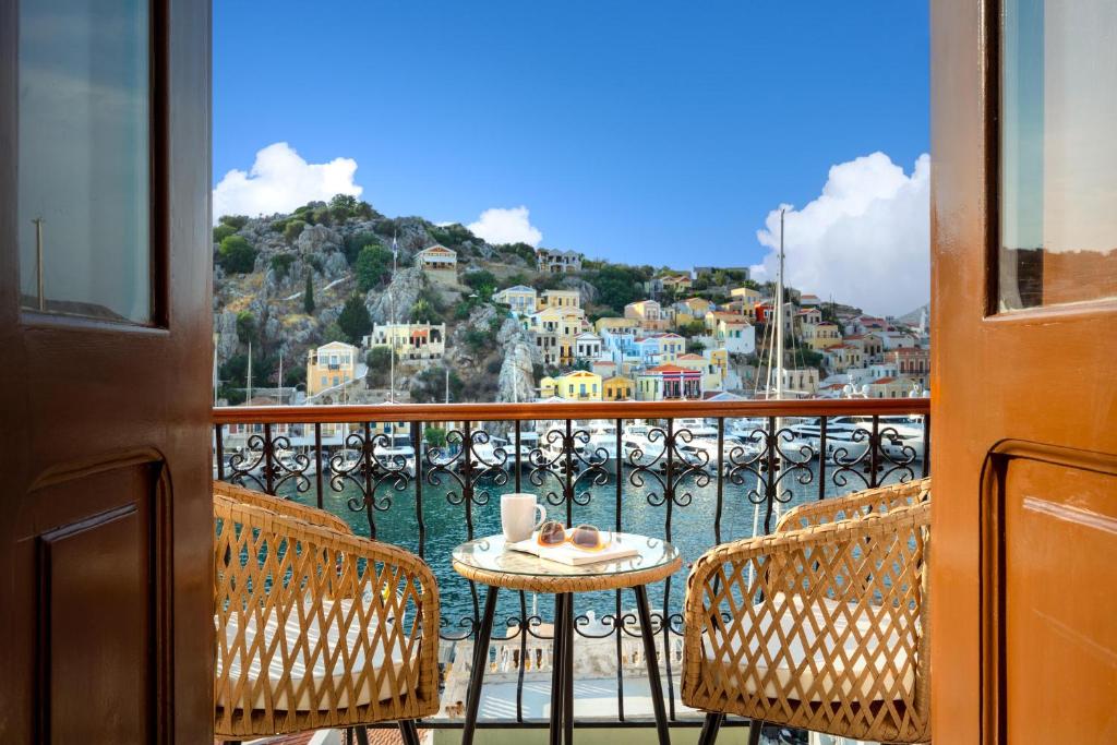 a table and chairs on a balcony with a view of the water at Annikas Port View-1st Floor in Symi