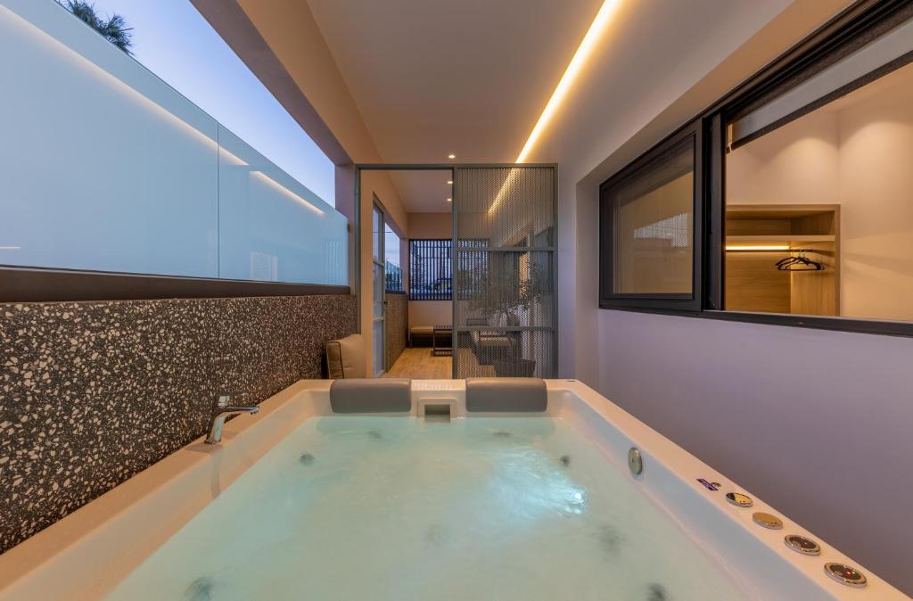 a bath tub in a bathroom with a large window at Hot Tub - 5 min to Beaches - Netflix - Full Kitchen in Kos