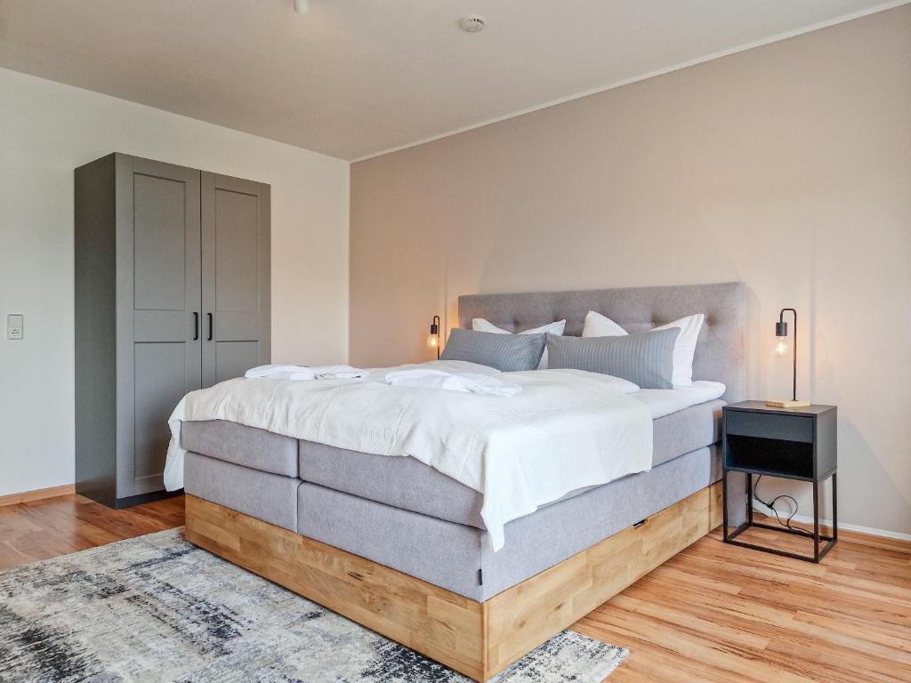 een slaapkamer met een groot bed en een nachtkastje bij RR - NEW - Apartments Kappel - 85qm - Lift - WIFI in Chemnitz