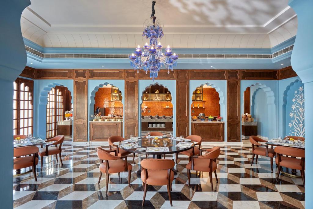a dining room with tables and chairs and a chandelier at Mementos by ITC Hotels Jaipur in Jaipur