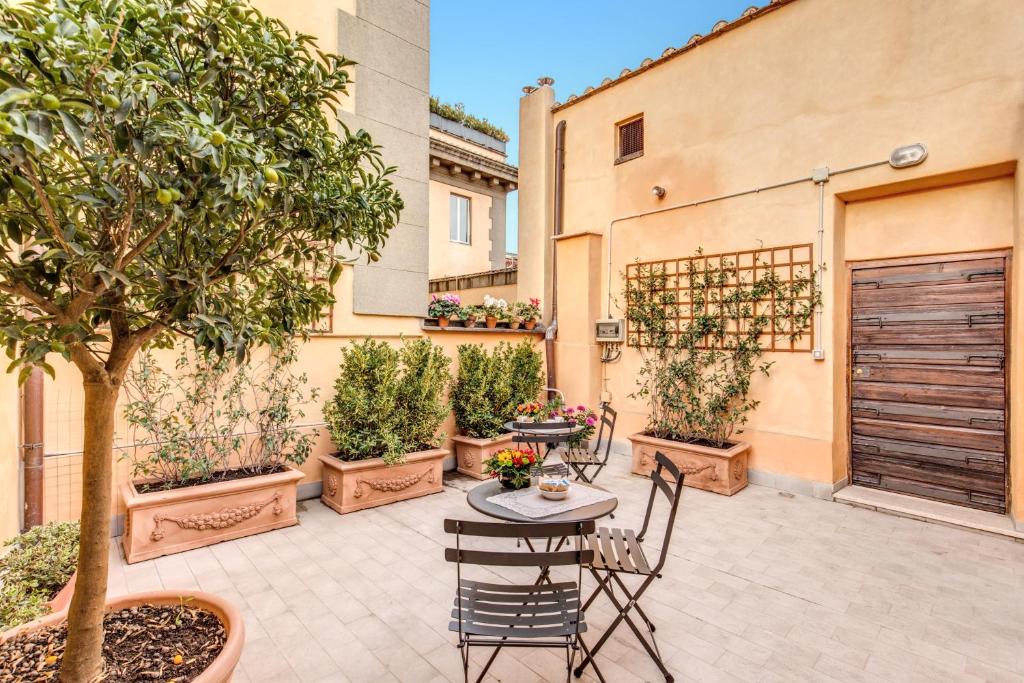 a patio with a table and chairs and trees at Gonfalone 6 in Rome