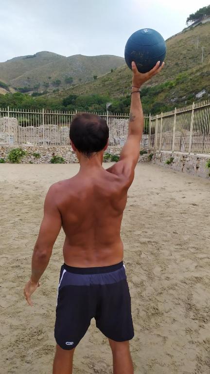 a man holding a blue ball in the air at La Flacca Rooms in Sperlonga