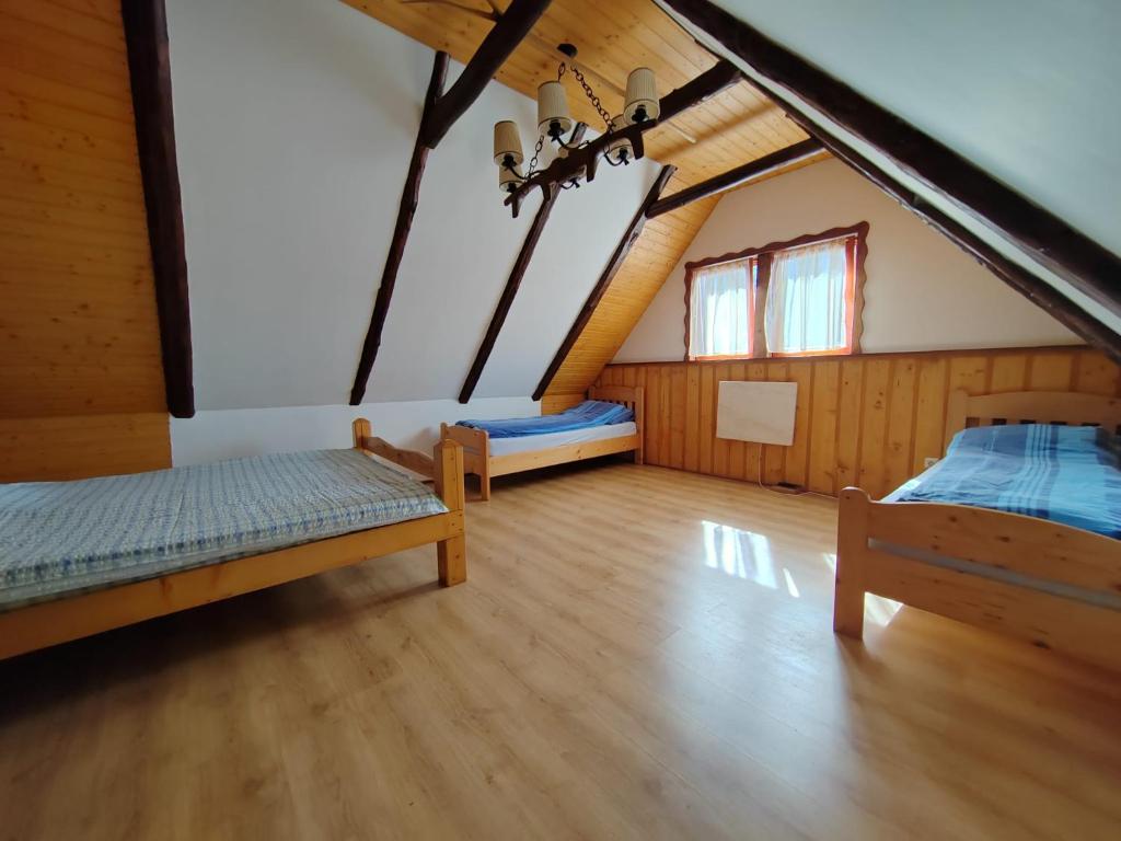 a room with two beds in a attic at Casa Bunicului in Poplaca